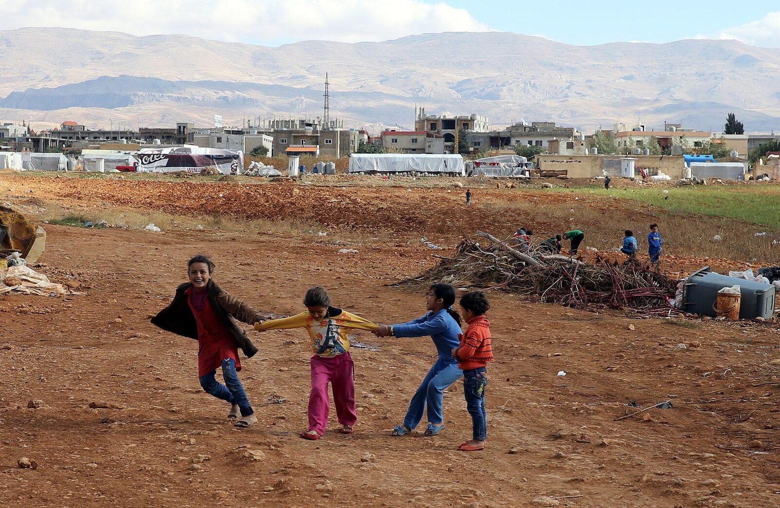 Children playing together, holding hands in a line